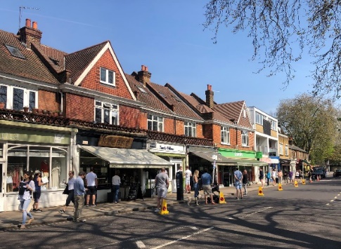 Part of roadway coned off to give queuing shoppers space in Barnes